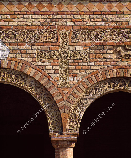 Gewölbter Säulengang. Detail mit bänderartigen Bändern und Kreuz mit Ranken