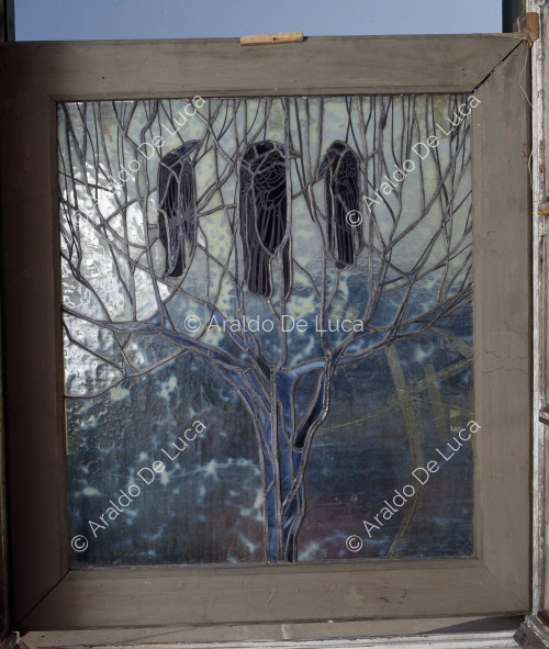 Buntglasfenster mit Baum und Krähen