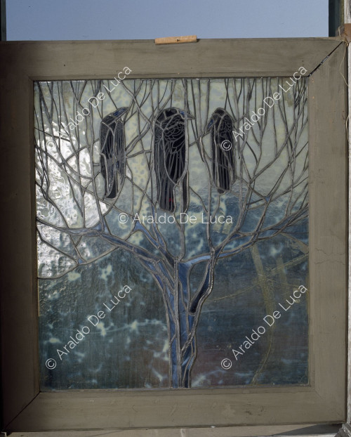 Stained glass window with tree and crows