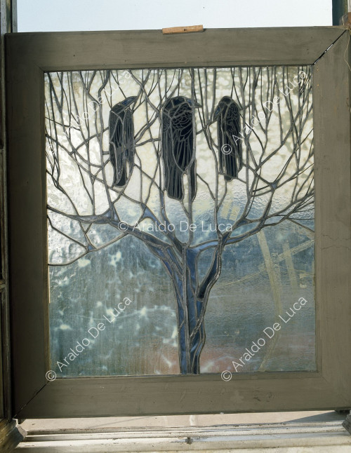 Buntglasfenster mit Baum und Krähen