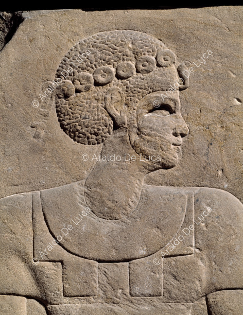 Relief with standing male figure. Detail