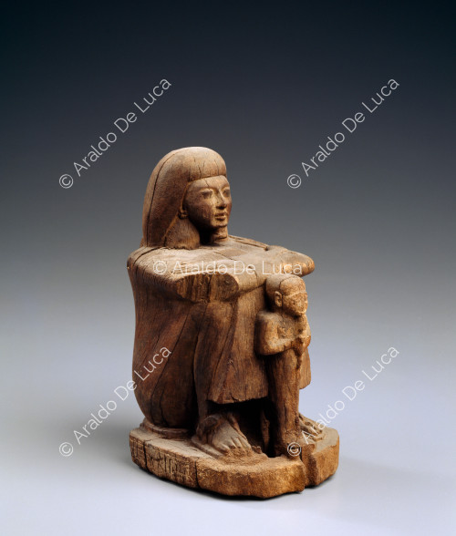 Estatua cúbica que representa a un hombre sentado con una representación de Ptha (dios creador) delante.