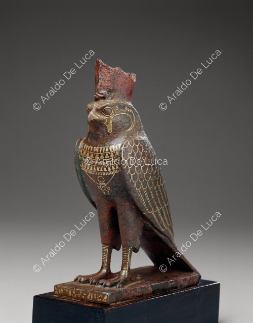 Estatua de Horus con imagen de halcón y amuleto en forma de corazón