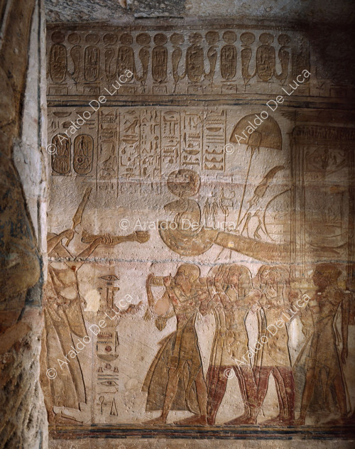 Ramesse offre incenso e lo scettro del potere davanti alla barca di Amon-Ra alla presenza di Nefertari che scuote i sistri