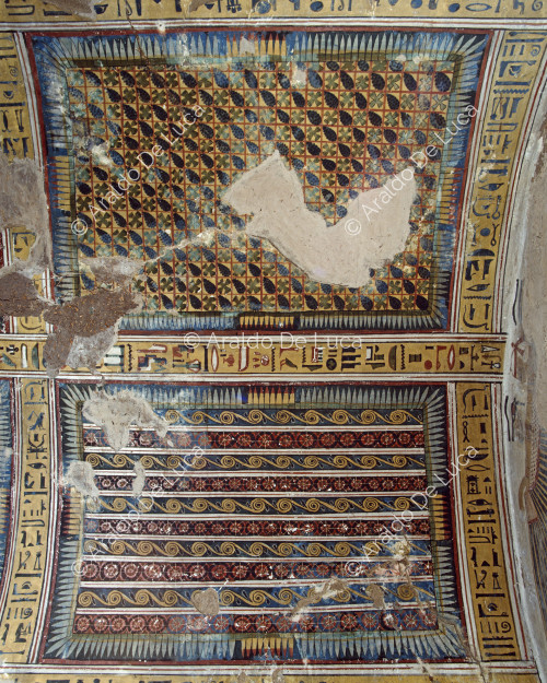 Decoración del techo de la primera sala: paneles con racimos de uvas y líneas geométrico-florales.