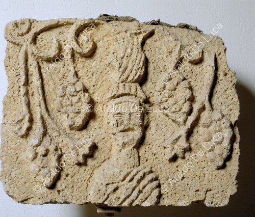 Relief with man and bunches of grapes