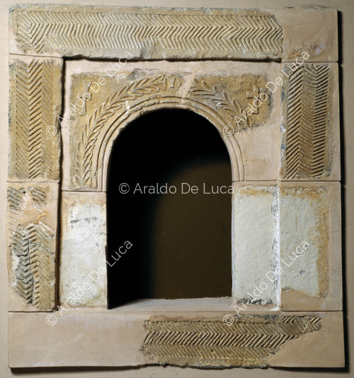 Arco de ventana de piedra decorado con motivos geométricos