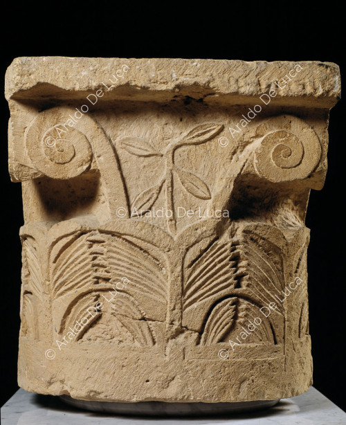 Capitel de piedra decorado con motivos vegetales y animales