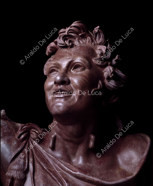 Statue de Faune ivre en rouge antique. Détail du visage