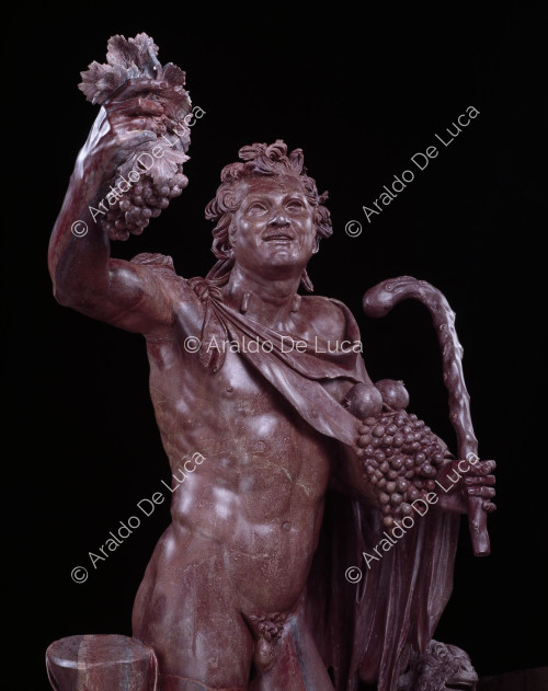 Statue of drunken Faun in antique red. Bust detail