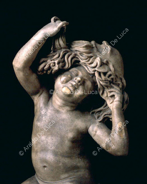 Estatua de un niño con máscara. Detalle del busto