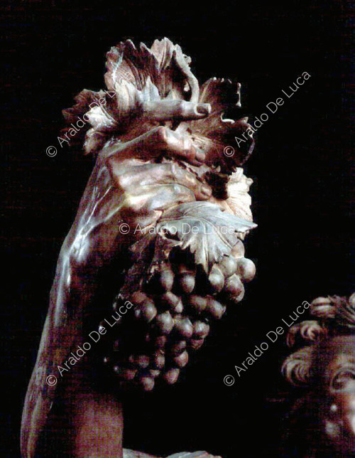 Statue de Faune ivre en rouge antique. Détail de la main droite
