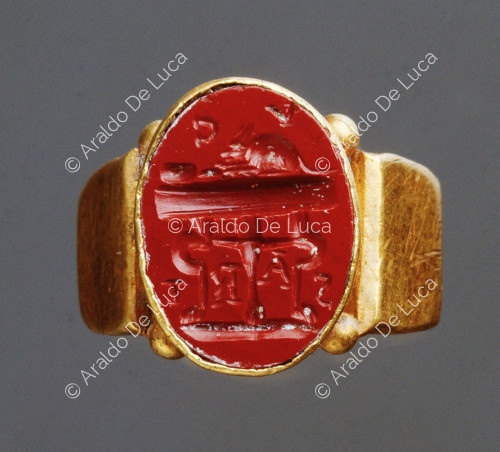 Carved ring with curved three-legged table