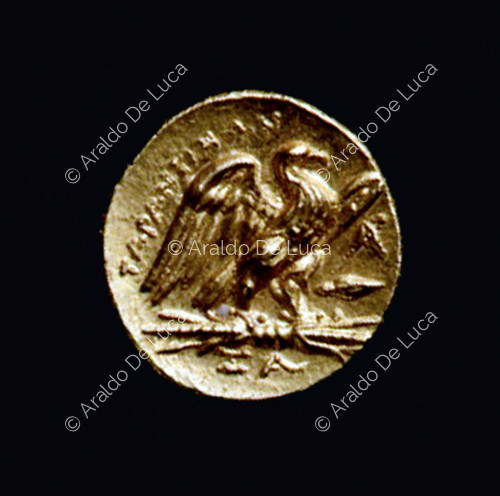 Moneda con águila en pie con las alas abiertas sobre un rayo