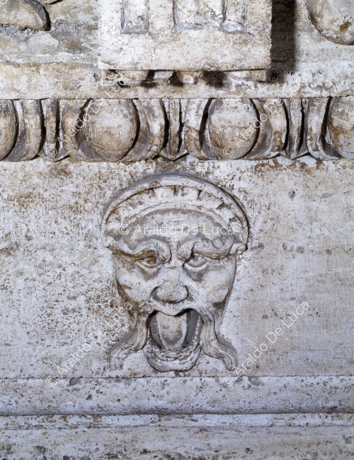 Grotesque mask in travertine