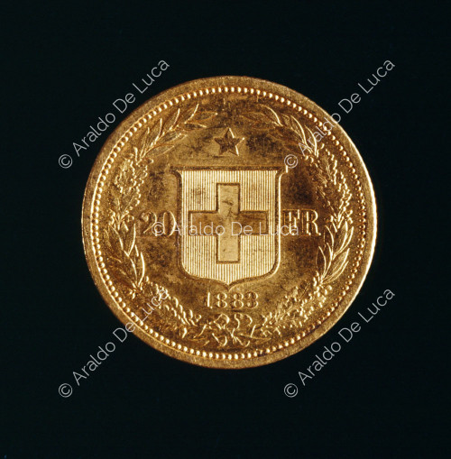 Croce Svizzera in scudo circondato da corona d'alloro, in alto stella, 20 Franchi Svizzeri d'oro della Confederazione Elvetica