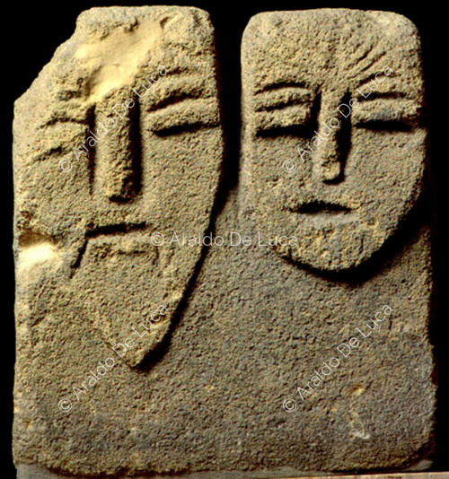 Stèle votive avec un visage humain