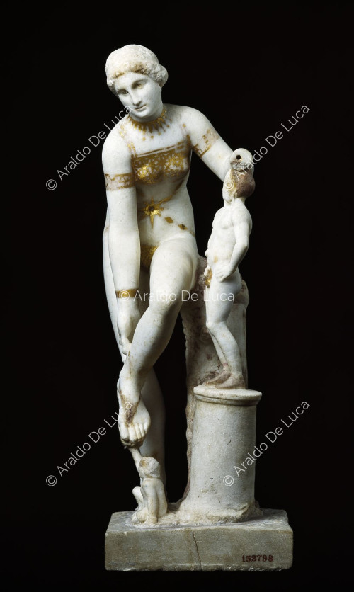Statue der Venus im Bikini beim Binden einer Sandale