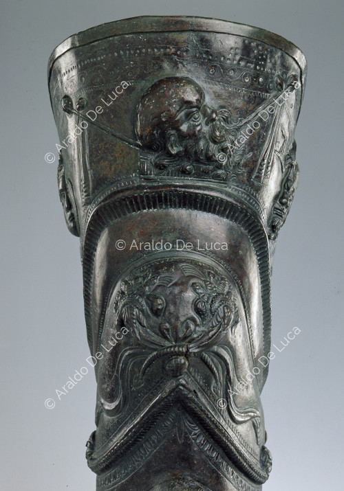 Bronze Schiniera. Detail with cornucopia