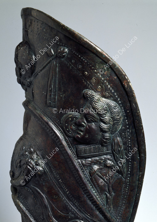Schiniera aus Bronze. Detail mit männlichem Kopf