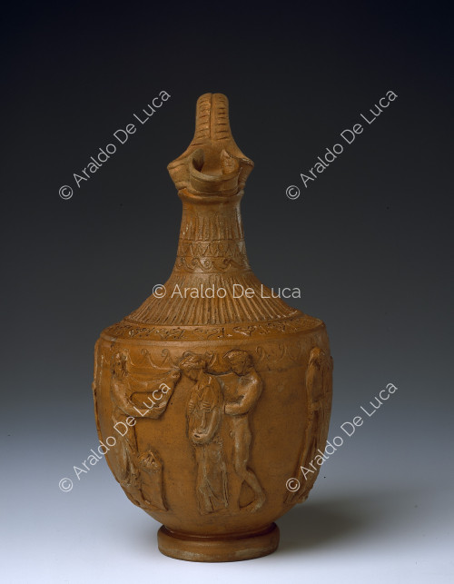 Pitcher with bearded mask and six human figures