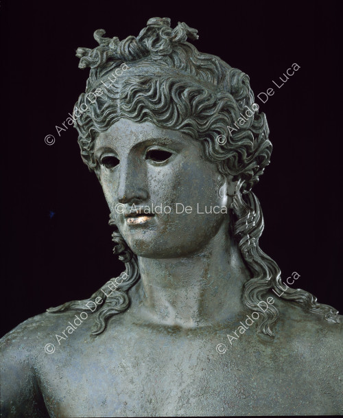 Bronze statue of naked Dionysus. Detail of the face