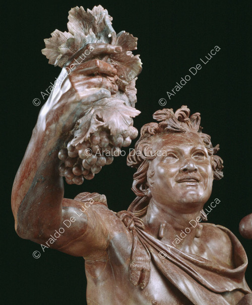 Estatua de Fauno borracho en rojo antiguo. Detalle del busto